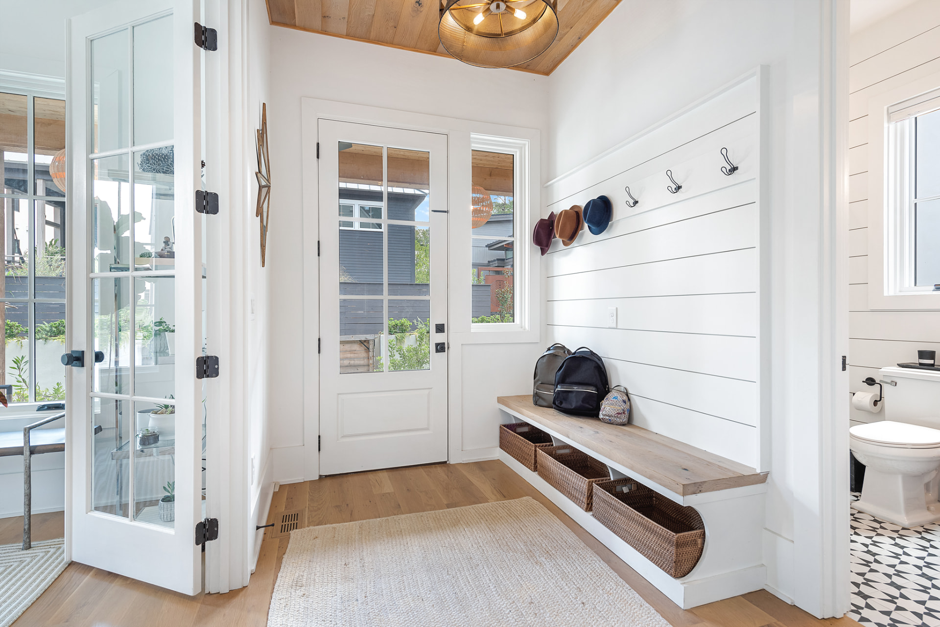 Mudroom with floating oak bench, shiplap hooks and cedar-clad ceiling