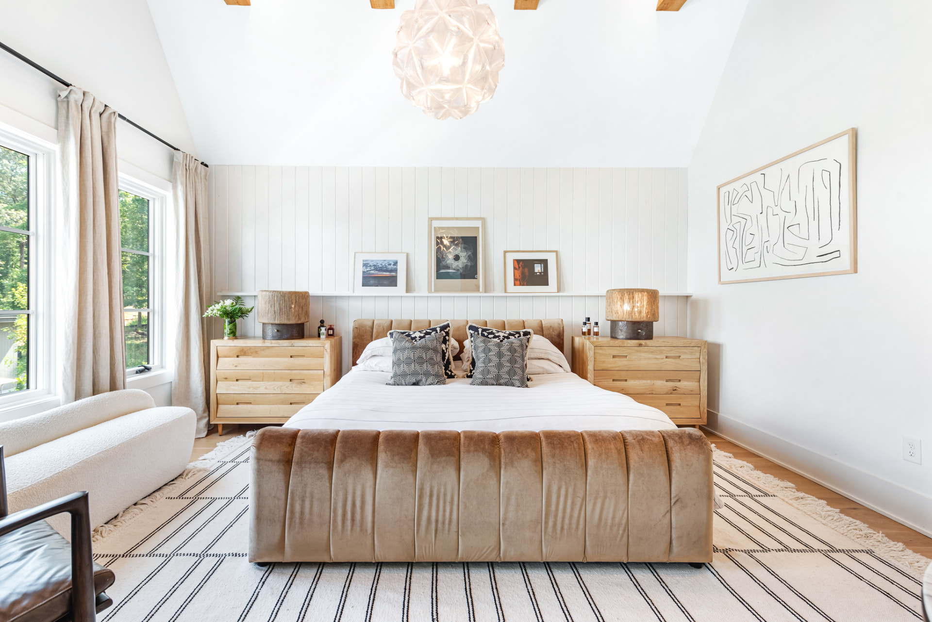 Primary bedroom with channelled velvet bed, shiplap wall and glass-flower pendant