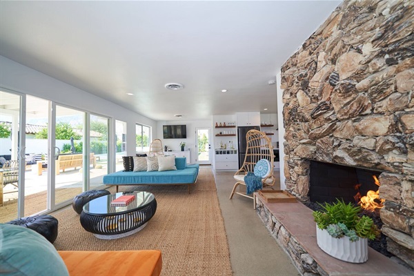 Great room looking to the pool sliders past the stone chimney