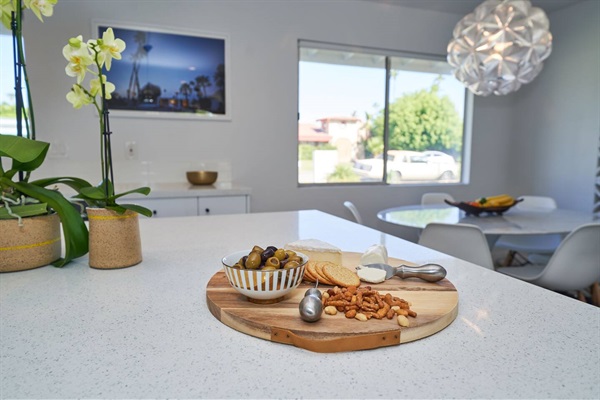 Quartz kitchen island with orchids, board and faceted glass pendant