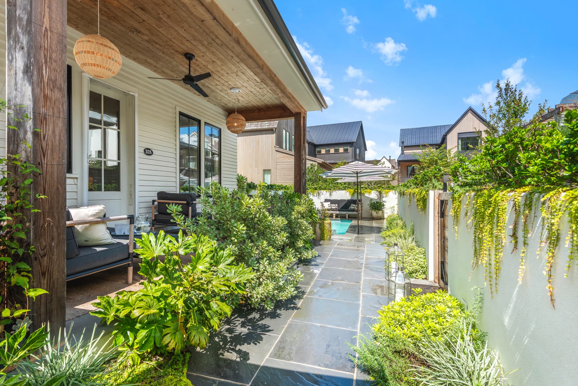 Covered porch opening to a bluestone garden path and pool courtyard