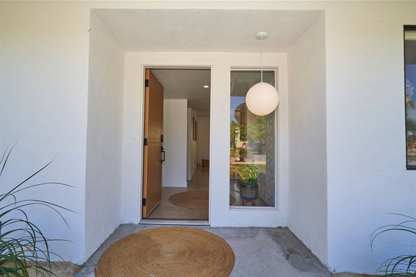 Front entry vestibule with opal globe pendant, oak door and jute rug