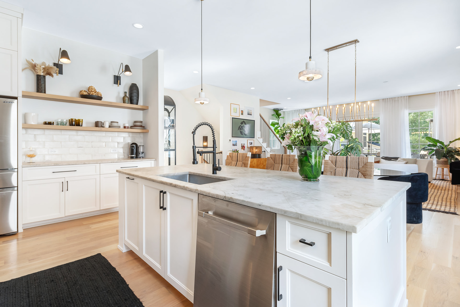 Kitchen island in quartzite with oak shelves and limewashed brick backsplash