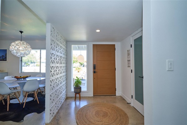 Entry with oak door, breeze-block screen, jute round rug and dining beyond