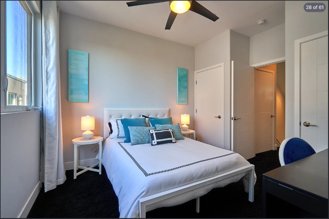 Guest room with tufted white headboard, teal watercolours and matching pillows