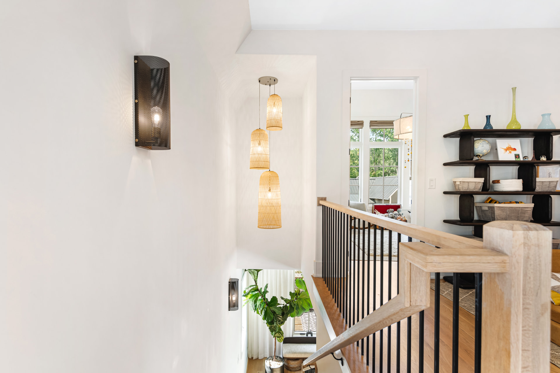 Upper landing with woven pendants, perforated sconce and open shelving