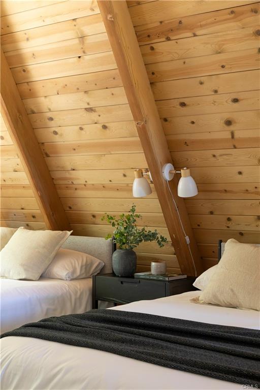 Detail of paired white sconces and a black nightstand between twin beds