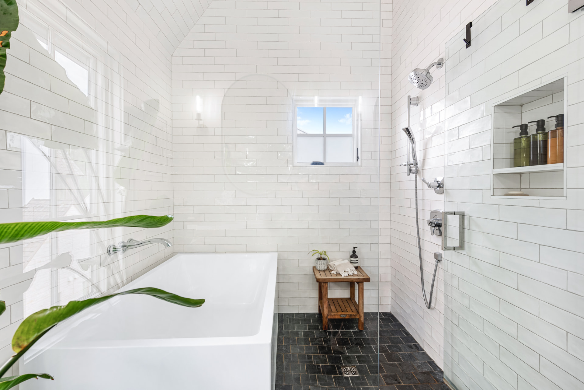 Wet room with soaking tub, white subway tile and slate herringbone floor