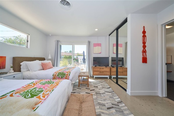 Twin guest room with hide rug, sliding doors to the garden and mirrored wall