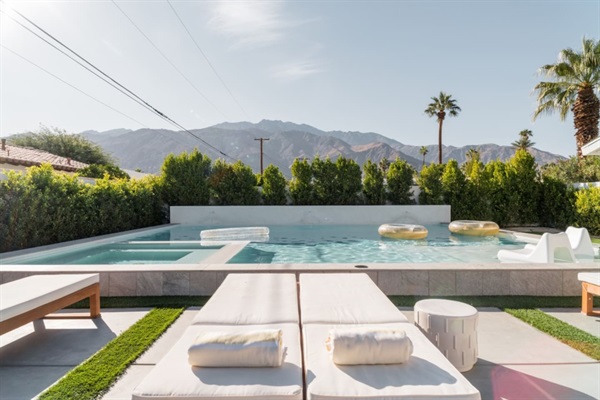 Pool terrace with double chaises, spa and mountain view