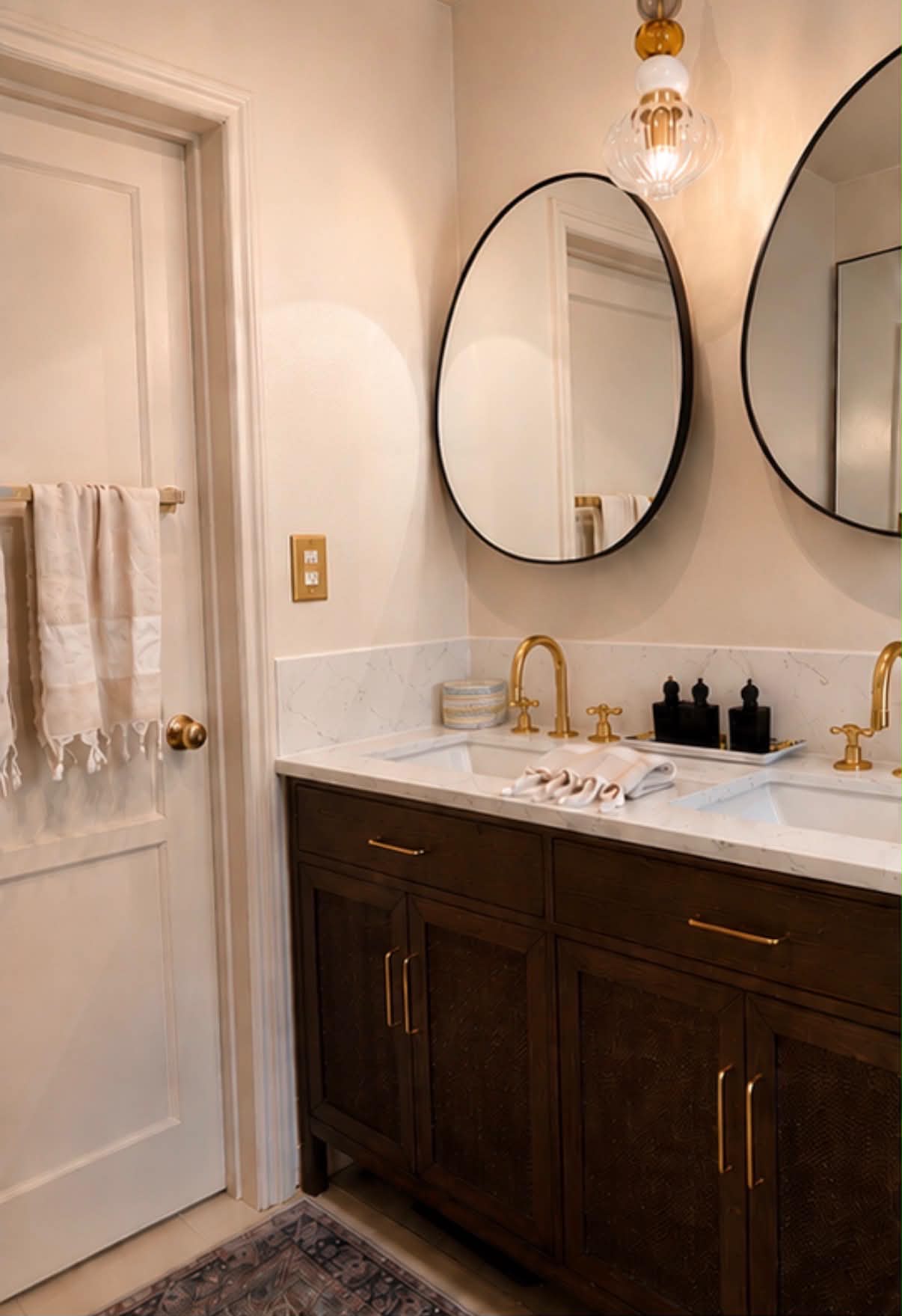 Double vanity in stained white oak with marble top and brass cross-handle fittings