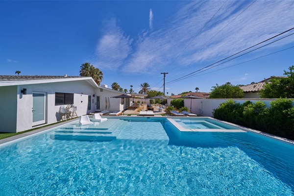 Pool and spa with in-water loungers and the house beyond