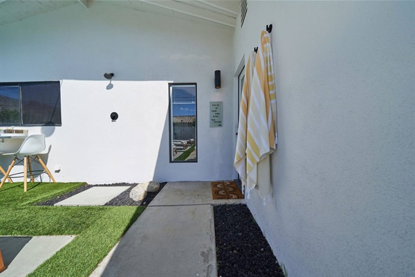 Outdoor shower passage with striped towels and stepping stones