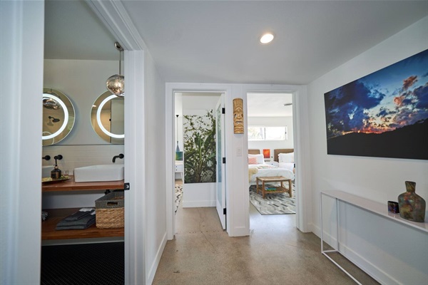 Hall with framed dusk photograph looking into bath and bedroom
