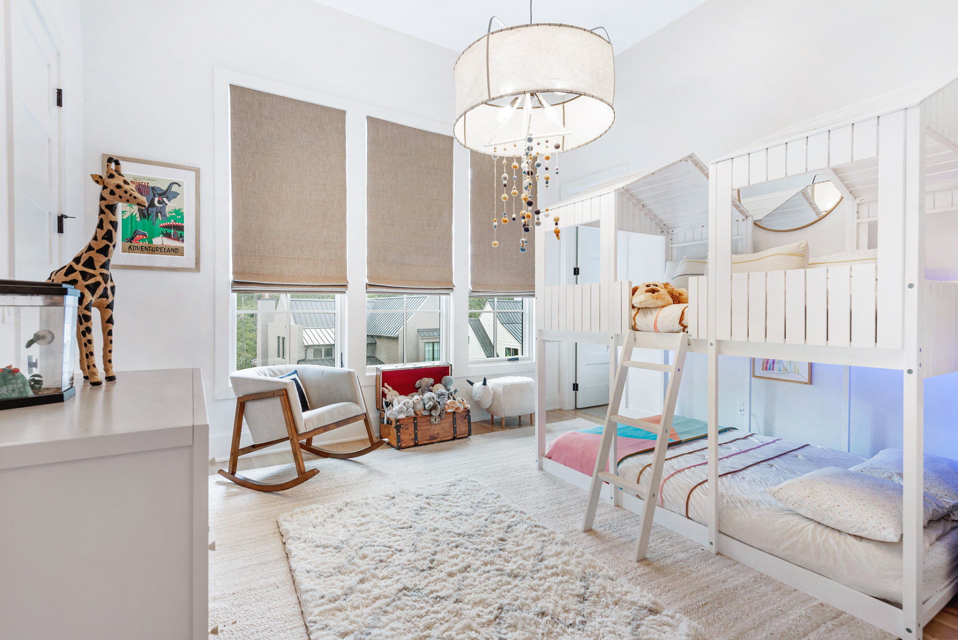 Children's room with house-frame bunk beds, linen drum pendant and felt-ball mobile