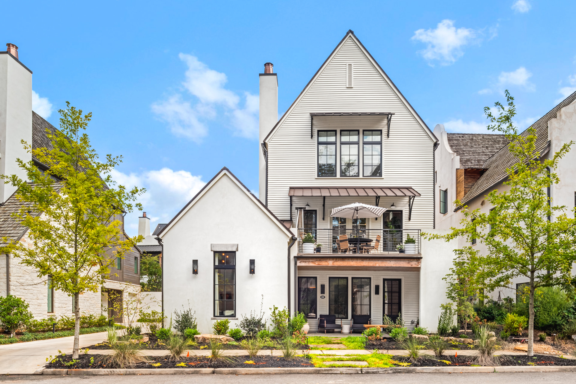 Front elevation of the white farmhouse with black-framed windows and porch