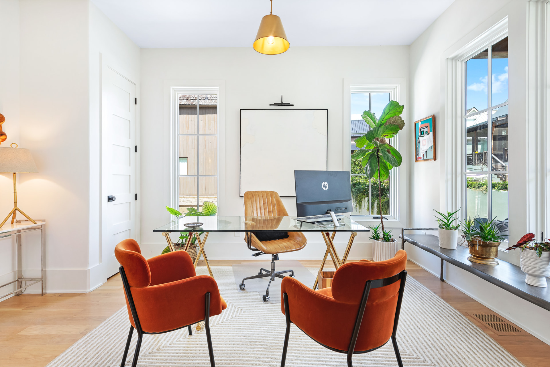 Study with glass desk, rust velvet chairs and brass cone pendant